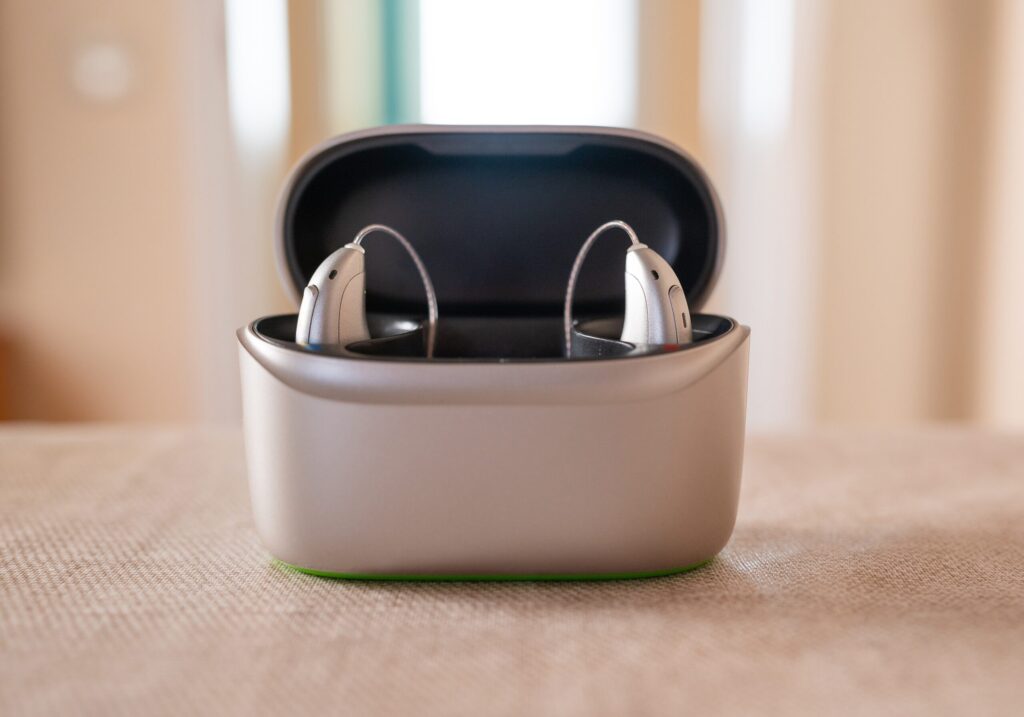 Pair of rechargeable receiver-in-canal hearing aids in an open charging case, for battery life tips from Port Elgin Audiology in Port Elgin, ON